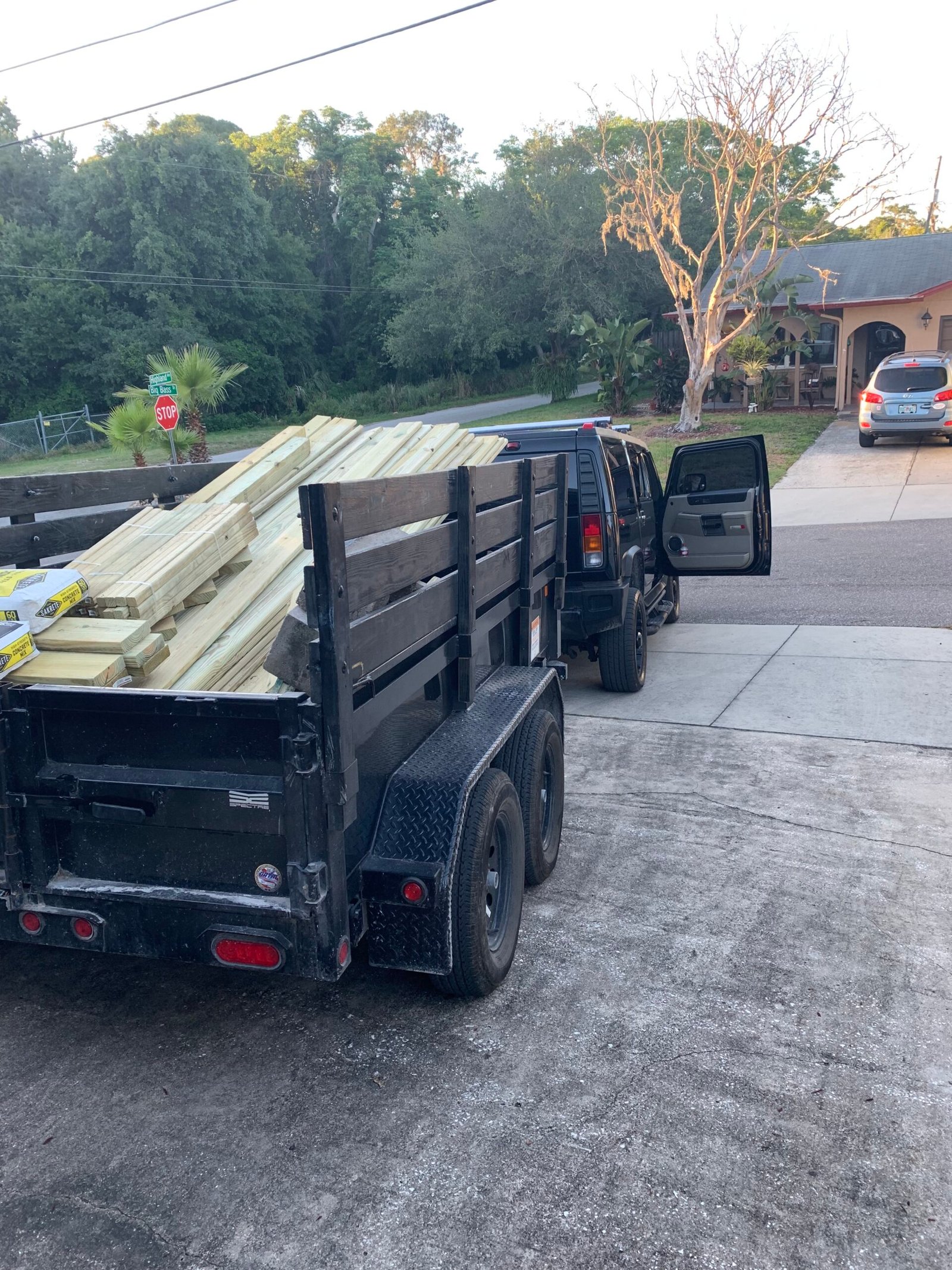 Junk Busters dump trailer loaded with wood and bulky debris during a Tampa Bay property cleanup