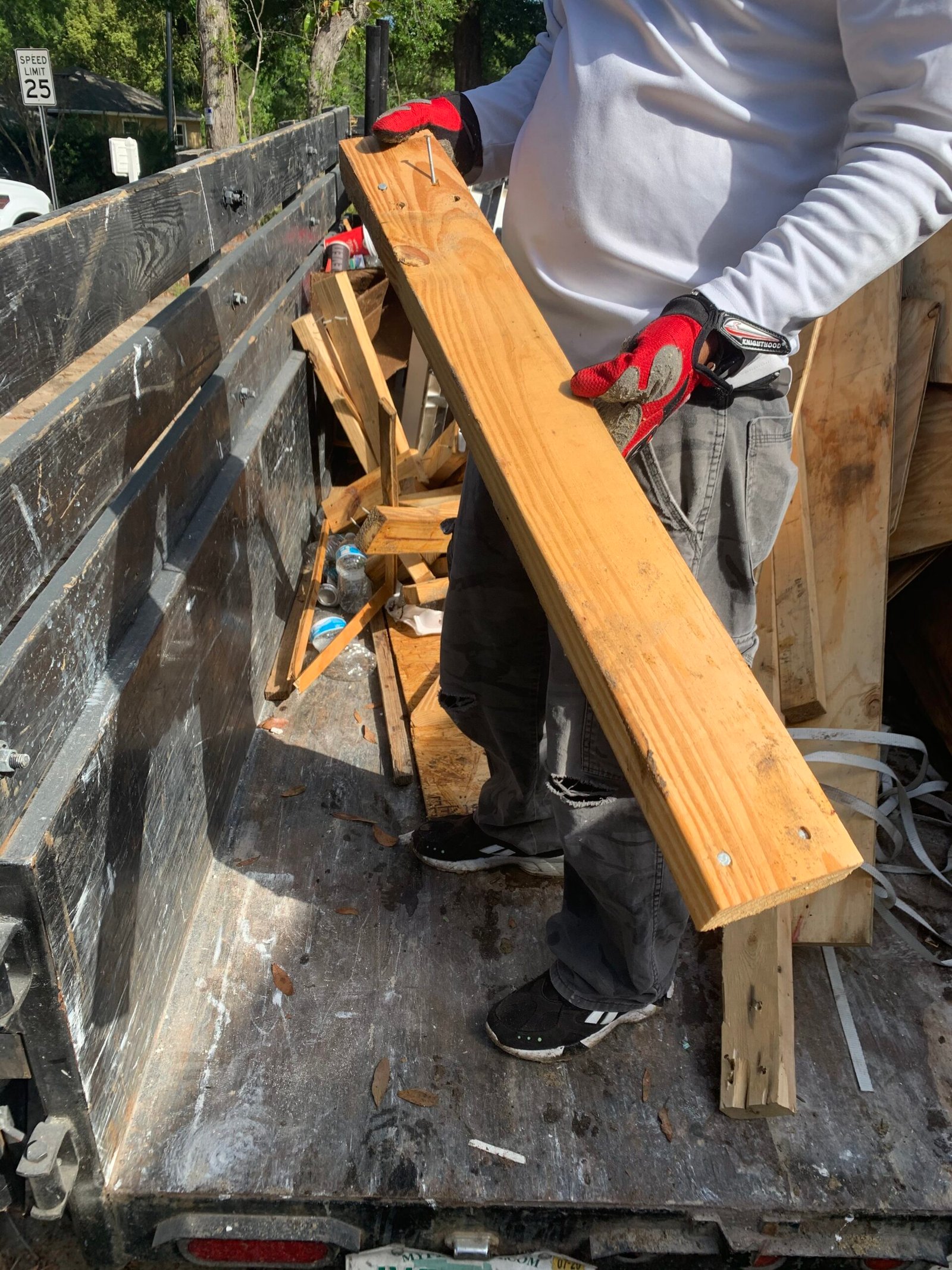 Junk Busters crew member loading wood and renovation debris into a trailer