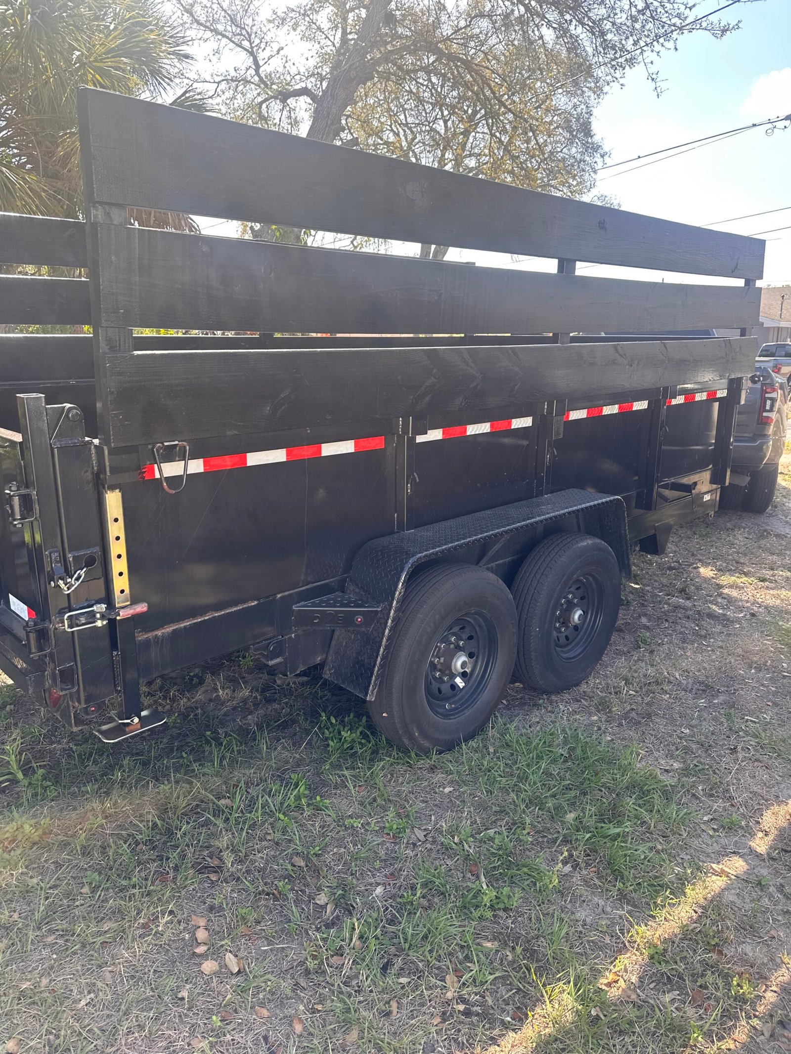 Side view of a Junk Busters dump trailer used for Tampa Bay cleanup projects